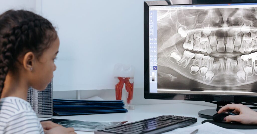 Dziecko z pluszakiem podczas wizyty adaptacyjnej u dentysty