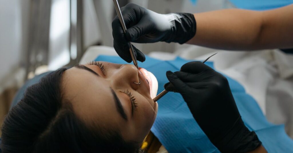 Dentysta bada jamę ustną pacjenta podczas konsultacji implantologicznej